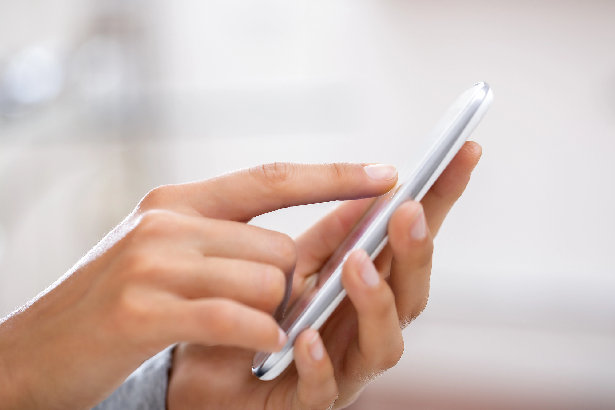 Woman holding a silver cell phone